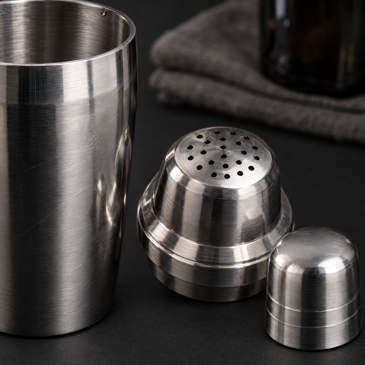 The 550 ml cobbler shaker taken apart into body, perforated strainer top and cap