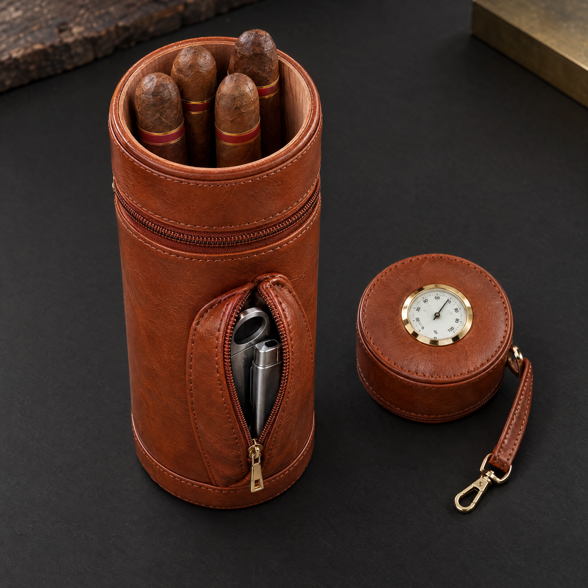The case open with four cigars in the cedar-lined barrel, the lid laid flat showing the hygrometer, and a cutter and lighter in the unzipped front pocket